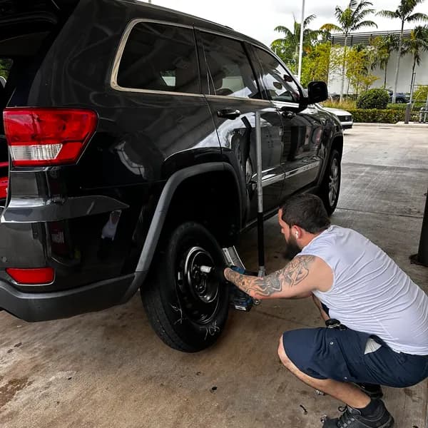 mobile tire technician changing a tire in Plantation, FL
